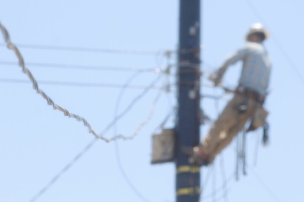 Blurry photo of utility worker on a pole