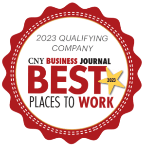 A circular white badge outlined in a wavy red border with text that reads "2023 Qualifying Company CNY Business Journal Best Places to Work".